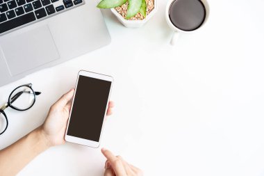 Boş ekranı tutan akıllı telefon fotokopi alanı ve üst görünümü olan ofis masasında.