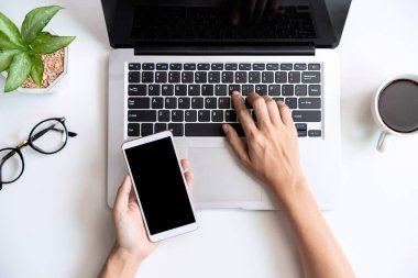 Boş ekranı tutan akıllı telefon fotokopi alanı ve üst görünümü olan ofis masasında.