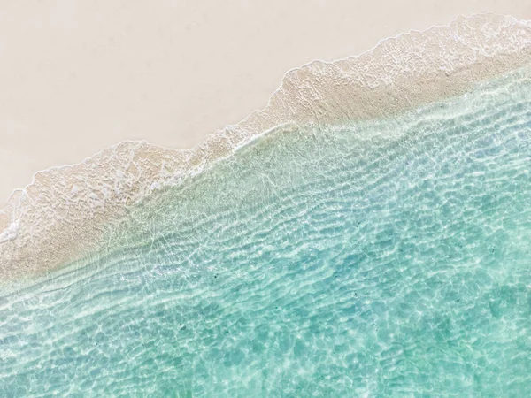 Dalgalı ve şeffaf deniz, yaz tatili ve fotokopi alanı ile seyahat arka planı olan güzel tropikal beyaz kumsal manzarası.