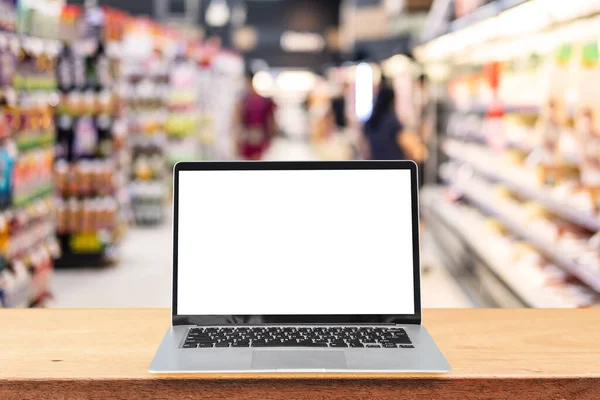 Tomma Skärmen Laptop Ett Träbord Med Abstrakt Suddig Bild Stormarknad — Stockfoto