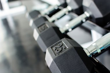 Bir spor salonunda bir raf üzerinde halter satırlar