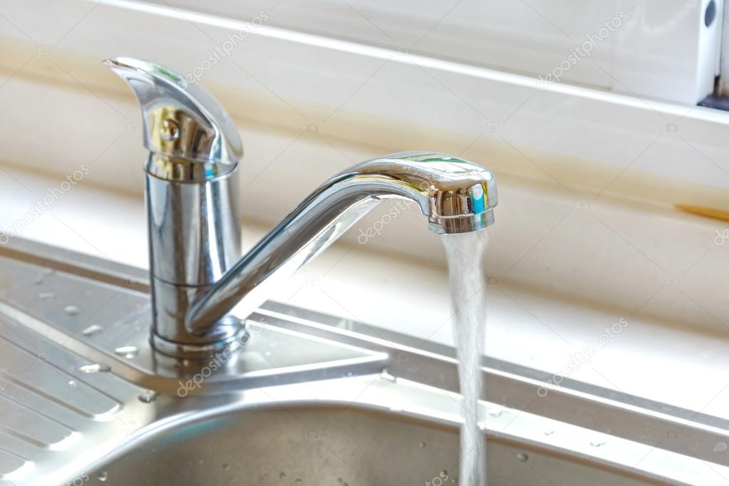 Kitchen faucet with a flowing water