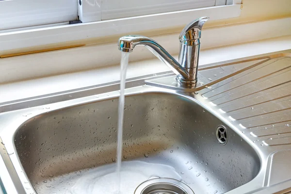 Kitchen faucet with a flowing water — Stock Photo, Image