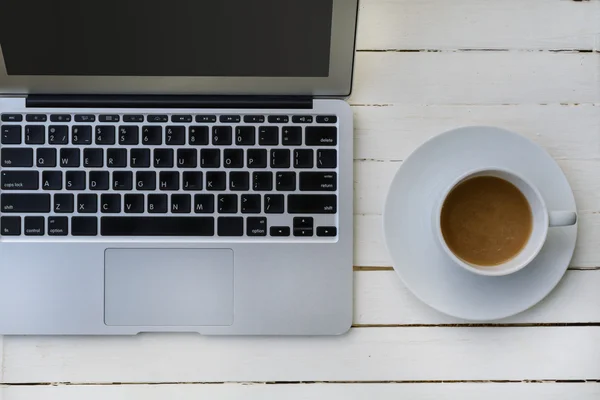 Tazza di caffè e laptop sul tavolo di legno — Foto Stock