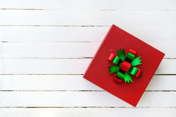 Red gift box on white wooden table — Stock Photo, Image