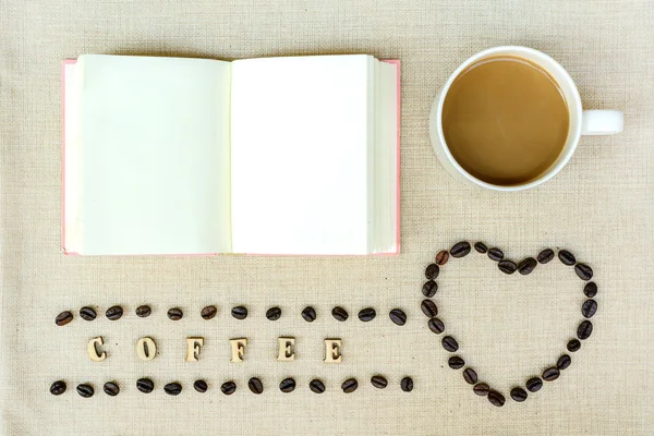 Prázdné notebook s šálkem kávy a fazole — Stock fotografie