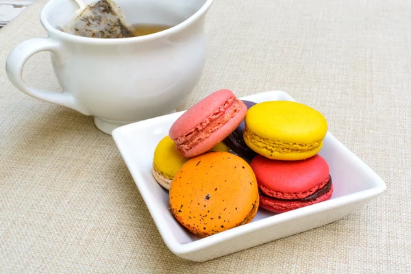 Macaroons coloridos e uma xícara de chá — Fotografia de Stock