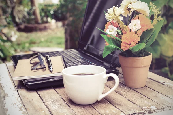 Cup of coffee and laptop on wooden table — Stock Photo, Image