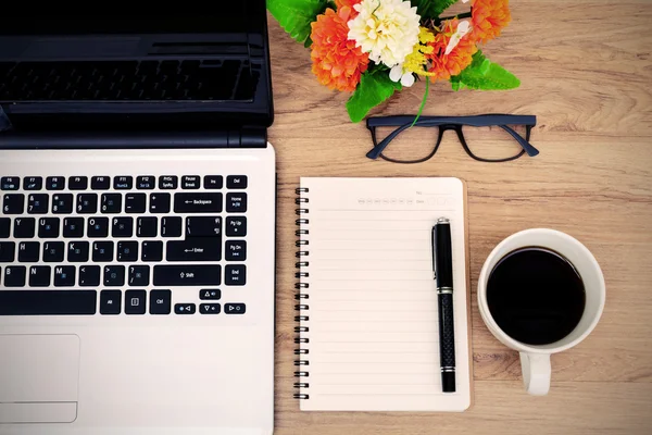 Portátil y taza de café con flores en el escritorio — Foto de Stock