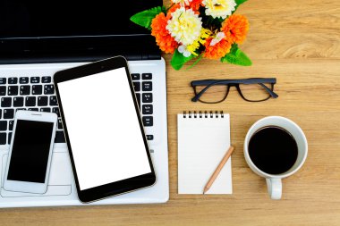 Laptop ve kahve masasında çiçek