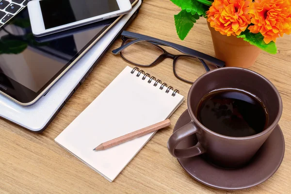 Portátil y taza de café con flores en el escritorio — Foto de Stock