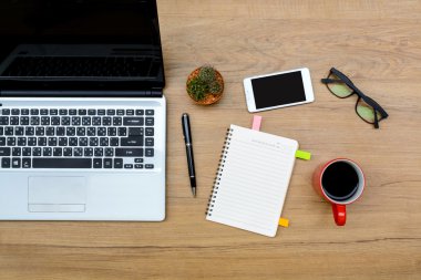 Laptop ve notebook ve cep telefonu üstünde okul sırası ile kahve