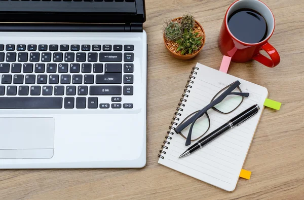 Laptop och kopp kaffe med anteckningsboken på skrivbord — Stockfoto