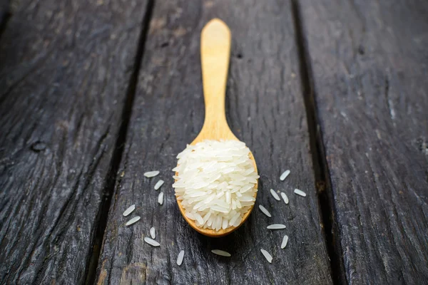 Riz à la cuillère en bois sur vieux bois — Photo