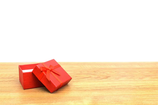 Červená dárková krabička na dřevěný stůl s kopií prostor — Stock fotografie