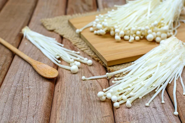 Fungo di Enoki con cucchiaio sul tavolo di legno — Foto Stock