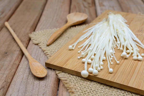 Fungo di Enoki con cucchiaio sul tavolo di legno — Foto Stock