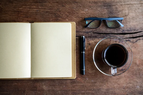 Cup of coffee with notebook on old wood — Stock Photo, Image