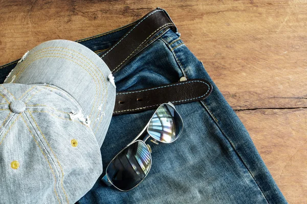 Blue jean and cap on old wood — Stock Photo, Image