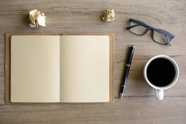 Cup of coffee with notebook on desk