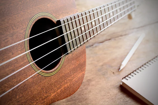 Primer plano del ukelele sobre fondo de madera vieja con luz suave —  Fotos de Stock