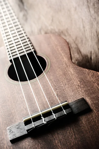 Primer plano del ukelele sobre fondo de madera vieja con luz suave —  Fotos de Stock