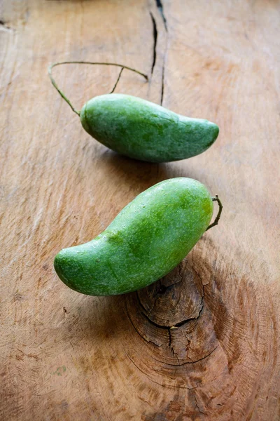 Green mango on old wooden table — Stockfoto