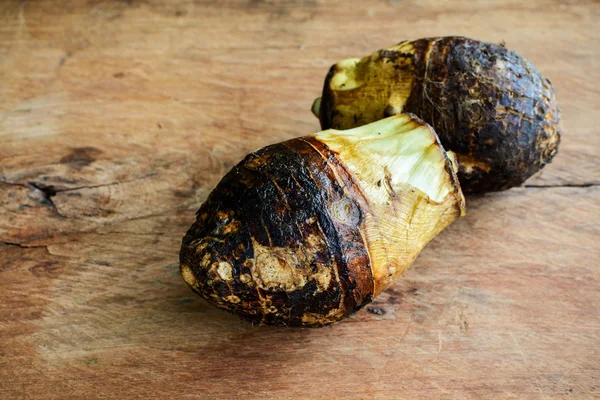 Raiz de taro na mesa de madeira velha — Fotografia de Stock