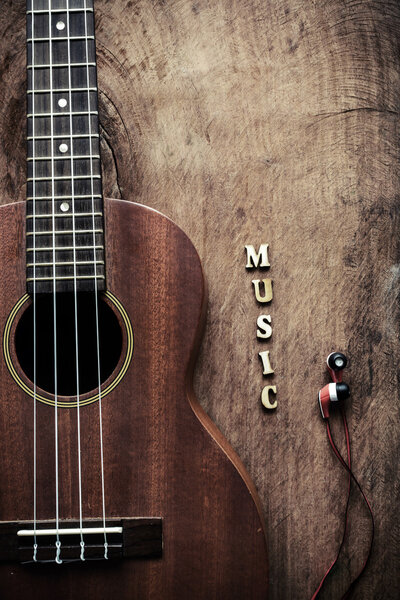 Primer plano de ukelele y auricular sobre fondo de madera vieja — Foto de Stock