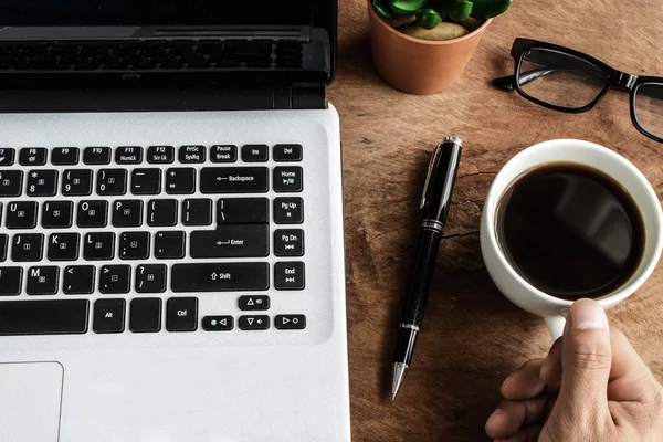 Ordinateur portable et tasse de café sur une vieille table en bois — Photo