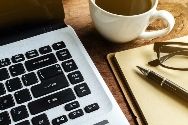 Laptop e tazza di caffè su vecchio tavolo in legno — Foto Stock