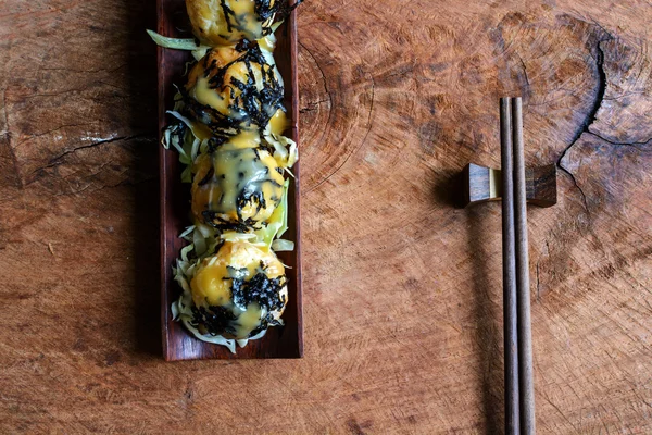 Poffertjespan op houten tafel met stokjes, Japans eten — Stockfoto