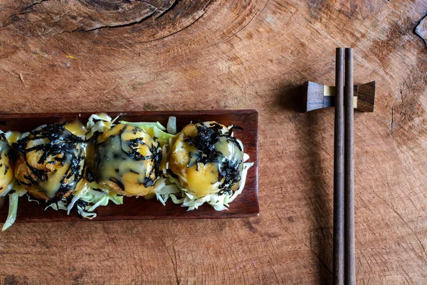 Poffertjespan op houten tafel met stokjes, Japans eten — Stockfoto