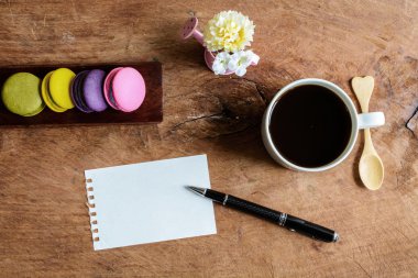 renkli macaroons kahve ve ahşap masa üzerinde boş Not