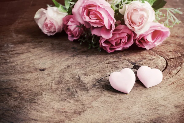 在木桌子上，复古色调的粉红色玫瑰花心形状 — 图库照片