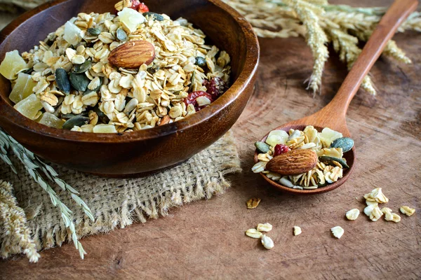 Copo de avena y granos de trigo integral en cuenco de madera sobre mesa de madera —  Fotos de Stock