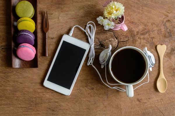 Színes macaroons és egy csésze kávé és a fából készült mobiltelefon — Stock Fotó