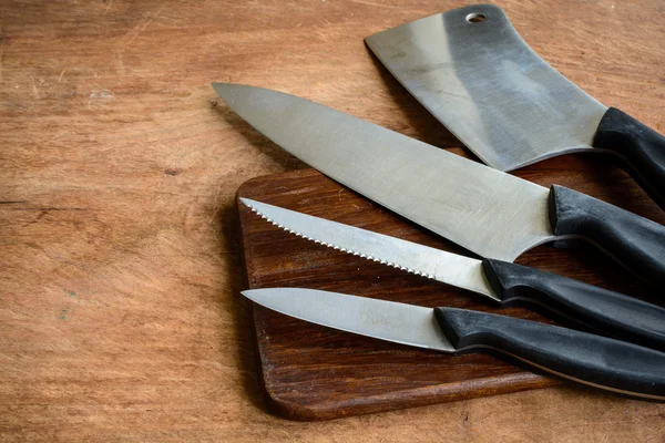 Juego de cuchillos de cocina sobre tabla de cortar de madera — Foto de Stock