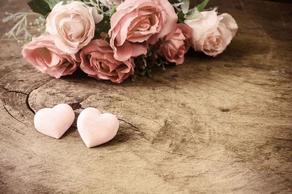 木製テーブルの上のピンクのバラの花とハート — ストック写真