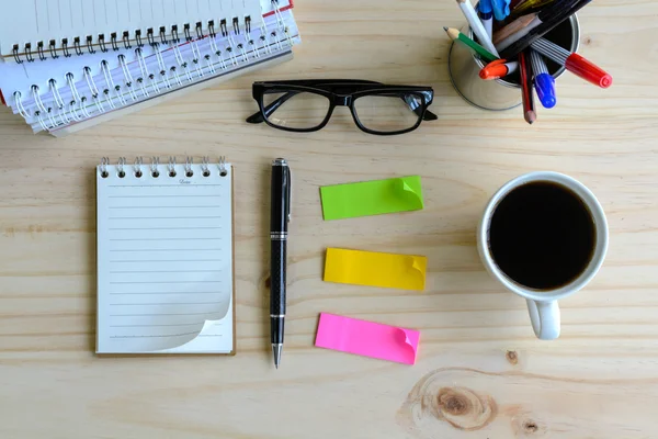 Cup of coffee with blank notebook on wooden desk — Stock Photo, Image