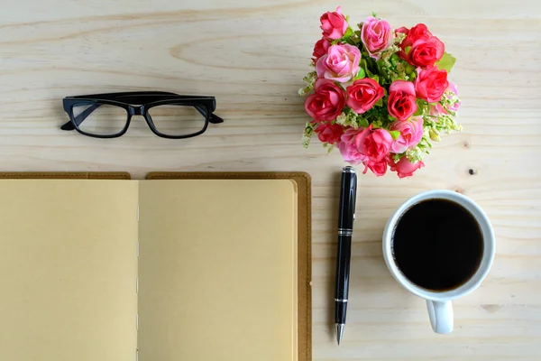 Taza de café con cuaderno y flor en el escritorio —  Fotos de Stock