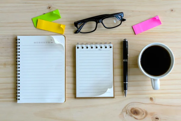 Cup of coffee with blank notebook on wooden desk — Stock Photo, Image