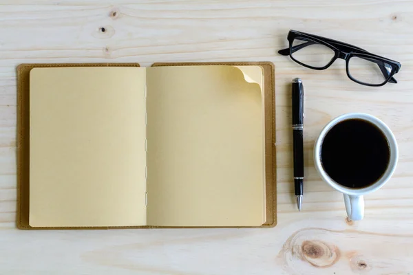 Ceașcă de cafea cu notebook gol pe birou de lemn — Fotografie, imagine de stoc