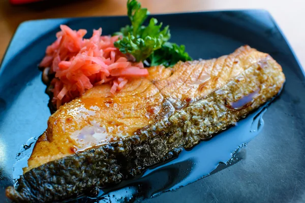 Filete de salmón y conservas de jengibre en plato negro — Foto de Stock