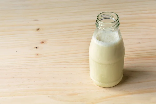 Botella de leche fresca sobre mesa de madera —  Fotos de Stock