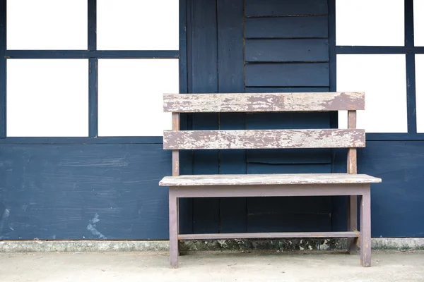 Banco de madeira velha com fundo de parede azul — Fotografia de Stock