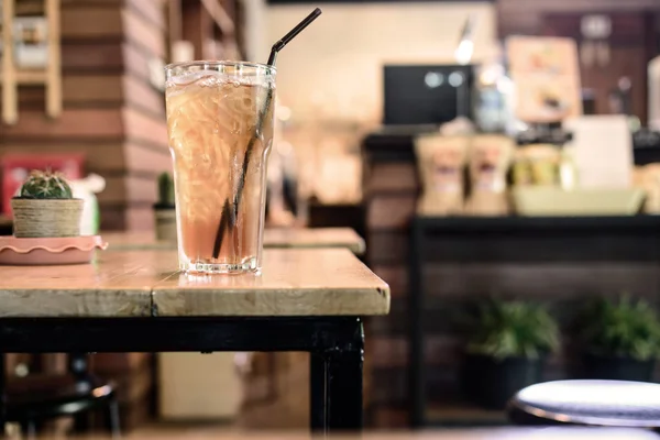 Vaso de té helado sobre mesa de madera en cafetería — Foto de Stock