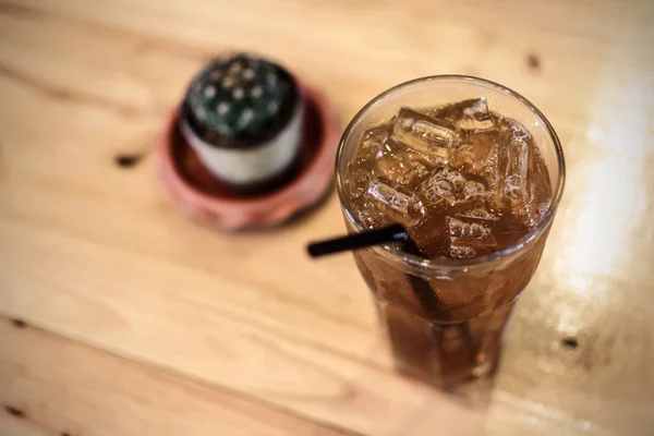 Vaso de té helado y cactus sobre mesa de madera — Foto de Stock