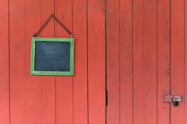 Blackboard opknoping op de oude houten deur — Stockfoto