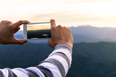 Akıllı telefon kullanan adam bir fotoğraf dağ görüş almak